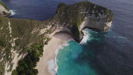 Stunning-White-Sand-Kelingking-Beach-with-Blue-Sea-and-Rocky-Peninsula-T-Rex-Cliff-in-Bali,-Indonesia-with-Turquoise-Blue-Water---Push-in-drone-reveal-shot