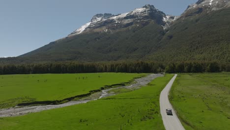 Car-on-gravel-road-from-Glenorchy-to-Paradise-in-scenic-valley,-New-Zealand