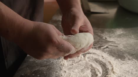 Kneading-dough-with-hands-for-pie-in-closeup,-homemade-pastry,-handheld-shot