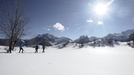 Un-Grupo-De-Excursionistas-Con-Raquetas-De-Nieve-A-Través-De-La-Nieve-En-Un-Paso-De-Montaña-En-Un-Día-Soleado