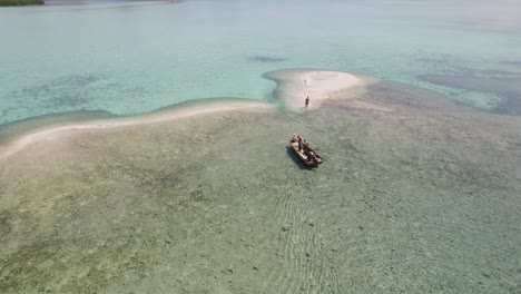 Kleine-Touristengruppe-Auf-Dem-Boot,-Das-Sich-Einer-Einsamen-Weißen-Sandinsel-Im-Komodo-nationalpark,-Indonesien,-Nähert---Antenne