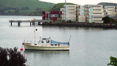 Boat-moored-at-Port-Chalmers,-shipping-containers-in-background