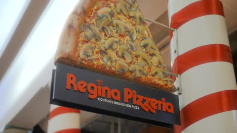 Outdoor-Sign-At-The-Famous-Regina-Pizza-In-Covered-Quincy-Market,-Boston,-Massachusetts,-USA---Low-Angle-Shot,-Closeup