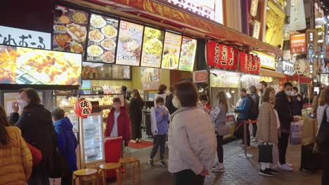 Streets-of-Dotonbori-at-Night,-People-Exploring-Street-Food-of-Japan