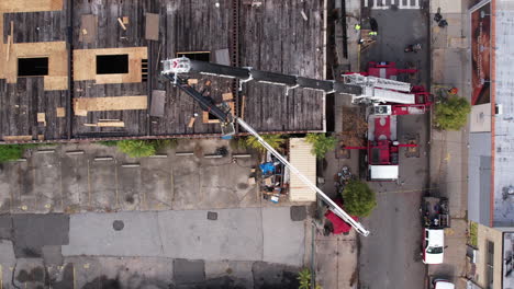 Top-Down-Drone-Shot,-Crane-Holding-Metal-Support-For-New-Builboard-Above-Old-Building-in-Brooklyn-Suburbs