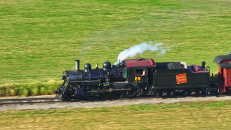An-Aerial-Zoomed-Parallel-View-of-a-Steam-Passenger-Train-Traveling-on-a-Single-Track-Thru-Countryside