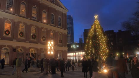 Gente-De-Pie-Alrededor-Del-árbol-De-Navidad-Frente-A-Faneuil-Hall-En-La-Noche-En-Boston,-Massachusetts,-Estados-Unidos