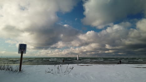 Exterior-wide-shot-of-a-man-running-with-his-dog-on-the-shores-of-a-wintry-Georgian-Bay