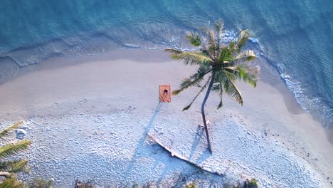 Yoga-girl-Lays-down-under-palmtree-at-Paradise-dream-seacret-beach