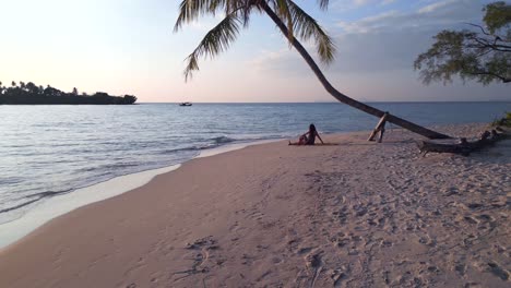 yoga-girl-stretches-under-palmtree-at-seacret-beach