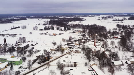 Kleines-Dorf-In-Lettland-Im-Winter-Mit-Schnee-Bedeckt,-Luftwagen-Herein