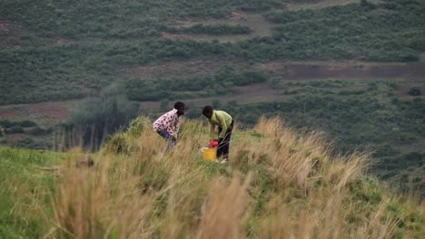 Junge-Afrikanische-Kinder-Bringen-Das-Mittagessen-Zu-Den-Bauern-Unterhalb-Einer-Luftigen-Graskuppe