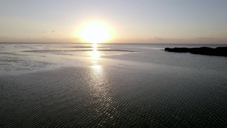 Drohnenaufnahme-Blick-Auf-Die-Strandwasserinsel-Mit-Sonnenuntergangshimmel