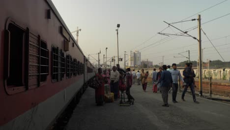 Train-standing-at-railway-station,-people-walking-at-platform,-Static-shot