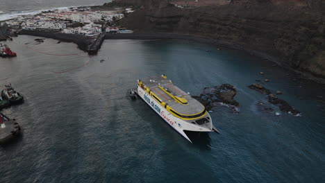 Aerial-shot-of-a-stranded-ferry-near-the-dock-of-the-port-of-Agaete-and-where-remains-of-fuel-are-shown