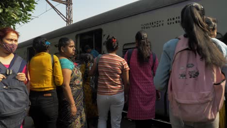 A-group-of-Indian-women-waiting-while-the-local-train-arrives-at-railway-station-platform