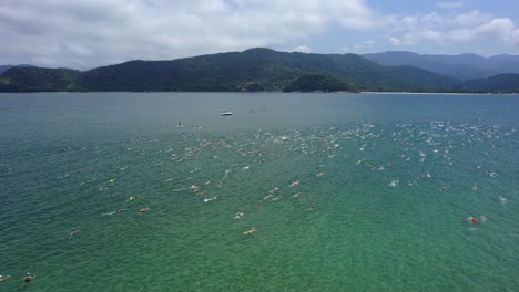 People-at-a-swimming-competition,-in-Barra-Do-Sahy,-sunny-Brazil---Aerial-view