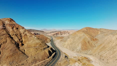 A-picturesque-highway-through-a-rocky-canyon-in-a-desert-landscape---sliding-aerial-view