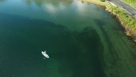 Blue-lake-tourist-on-paddle-bord-4k-drone-shot-in-New-Zealand