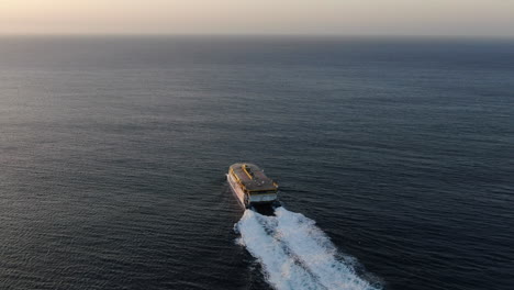 Fantastic-aerial-shot-from-the-stern-and-at-high-speed-of-the-ferry-leaving-the-port-of-Agaete-towards-Tenerife-during-sunset
