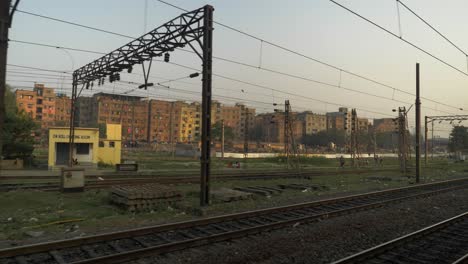 Side-view-of-railway-yard-from-a-moving-train-entering-slowly-at-the-railway-platform-junction-with-old-rustic-building-at-background