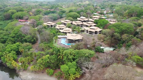Hotel-Nammbu-resort-in-Playa-Carrillo-Beach-with-ocean-shore,-Aerial-dolly-out-shot