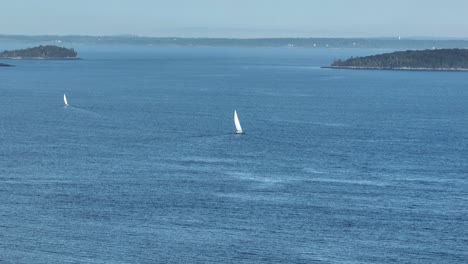 Two-sailboats-sailing-out-to-sea-vast-aerial-shot