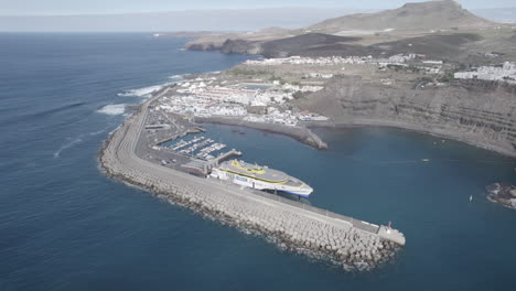 fantastic-aerial-shot-at-medium-distance-and-in-orbit-over-Ferry-docked-in-the-port-of-Agaete-on-a-sunny-day
