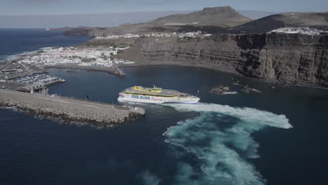 Fantastic-aerial-shot-of-the-Ferry-starting-the-docking-maneuver-in-the-port-of-Agaete-on-a-sunny-day