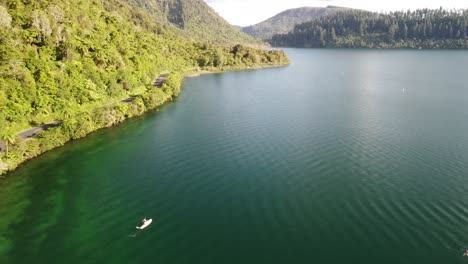 Lago-Azul,-Camino-Del-Bosque-De-Palmeras-Y-Turista-En-Paddle-Bord-4k-Drone-Disparado-En-Nueva-Zelanda