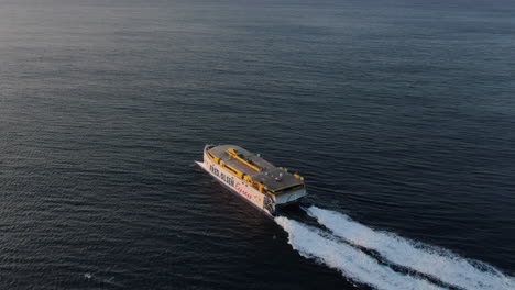Fantastic-lateral-aerial-shot-and-at-high-speed-of-a-ferry-leaving-the-port-of-Agaete-towards-Tenerife-during-sunset