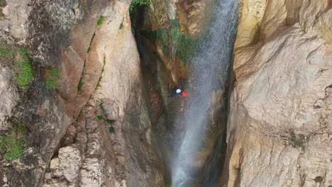 Bergsteiger-Durch-Wasserfall-Absteigend.-Luftaufnahme-In-Zeitlupe