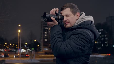 Male-photographer-taking-photos-with-Sony-a7iii-mirrorles-camera-at-night