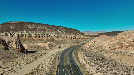 A-view-from-over-California-Highway-58-as-in-passes-through-a-canyon-between-sandstone-cliffs-on-a-clear-day-in-the-Mojave-Desert