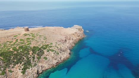Cala-Domestica-Cove,-Cliffs-and-Tower-in-Buggerru,-Sardinia,-Italy---4k-Aerial