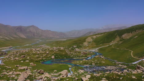 Szenische-Drohnenansicht-Aus-Der-Luft,-Die-über-Ein-Majestätisches-Bergtal-Und-Einen-Alpenfluss-In-Kirgisistan-Fliegt