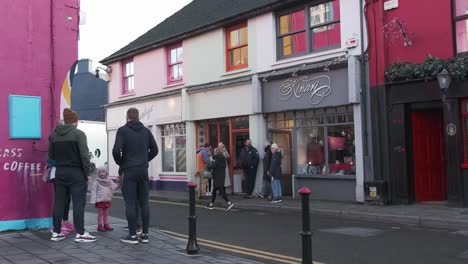 Christmastime-on-the-street-of-Kinsale,-Ireland-with-people-chatting,-walking-and-shops-are-open
