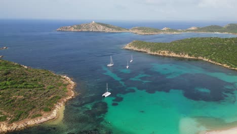 Turquoise-blue-bay-with-boats,-islands-and-Tuerredda-beach-in-Teulada,-Sardinia,-Italy---4k-Aerial