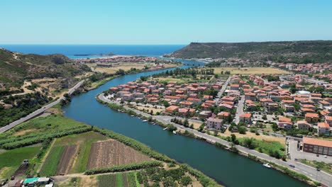 Temo-River-flows-through-Bosa-into-the-sea-at-Sardinia,-Italy---4k-Aerial