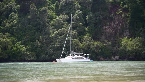 Yacht-floating-along-river-at-high-tide