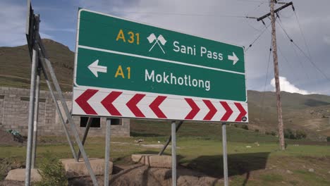Señal-De-Tráfico-En-Las-Montañas-De-Lesotho-Apunta-A-Sani-Pass-Y-Mokhotlong