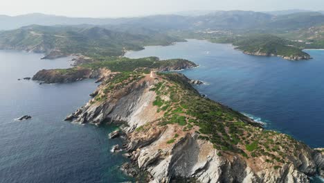 Capo-Malfatano-Rocky-Cliffs-at-South-Coast-of-Sardinia,-Italy---4k-Aerial-Reveal-Backwards