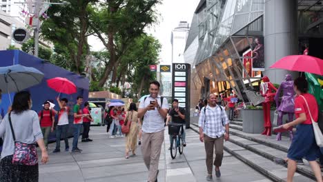 Singapur-Hombre-Feliz-Caminando-Por-La-Ciudad-De-Singapur-Con-Otros-Compradores