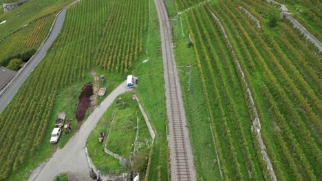 aerial-top-view-of-train-rails-in-Lavaux,-Switzerland,-vineyards