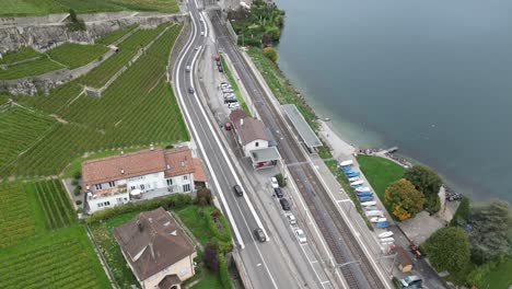 Vista-Aérea-De-Los-Automóviles-Que-Circulan-Por-Las-Carreteras-De-La-Región-De-Lavaux-Junto-Al-Lago-De-Ginebra,-Suiza
