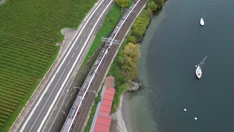 aerial-top-view-of-a-train-travelling-in-Lavaux-vineyards,-Vaud,-Switzerland