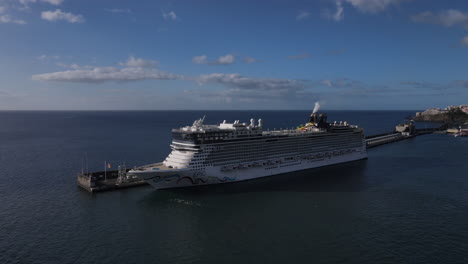 Fantastic-circling-aerial-shot-of-a-cruise-ship-docked-in-the-port-of-Funchal-on-the-island-of-Madeira-on-a-sunny-day