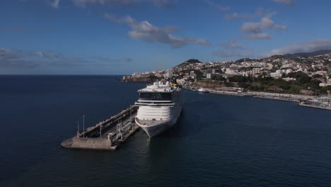 Half-circle-aerial-shot-of-the-bow-of-the-cruise-ship-docked-in-the-port-of-Funchal-on-the-island-of-Madeira-on-a-sunny-day