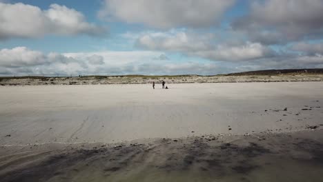 Luftaufnahme-Von-Drei-Personen-An-Einem-Sandstrand-In-Connemara,-Irland,-Mit-Blick-Auf-Den-Ozean