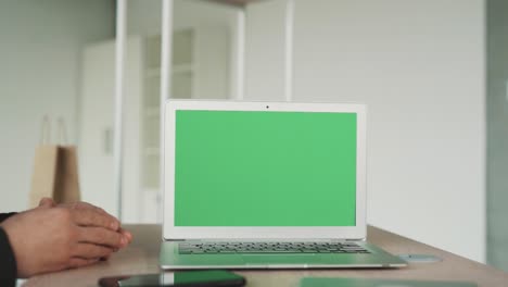 Nahaufnahme-Eines-Laptop-Bildschirms-Mit-Chroma-Key,-Zwei-Männliche-Hände-Zittern-Im-Hintergrund